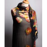 An early 20th Century black silk devoré shawl, decorated with stylised brightly coloured flowers.