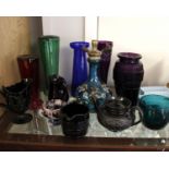 A collection of coloured glass ware to include an enamelled blue glass vase, crocus pots and other