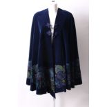 An early 20th Century dark blue velvet evening cape, with a stencilled hand painted stylised printed