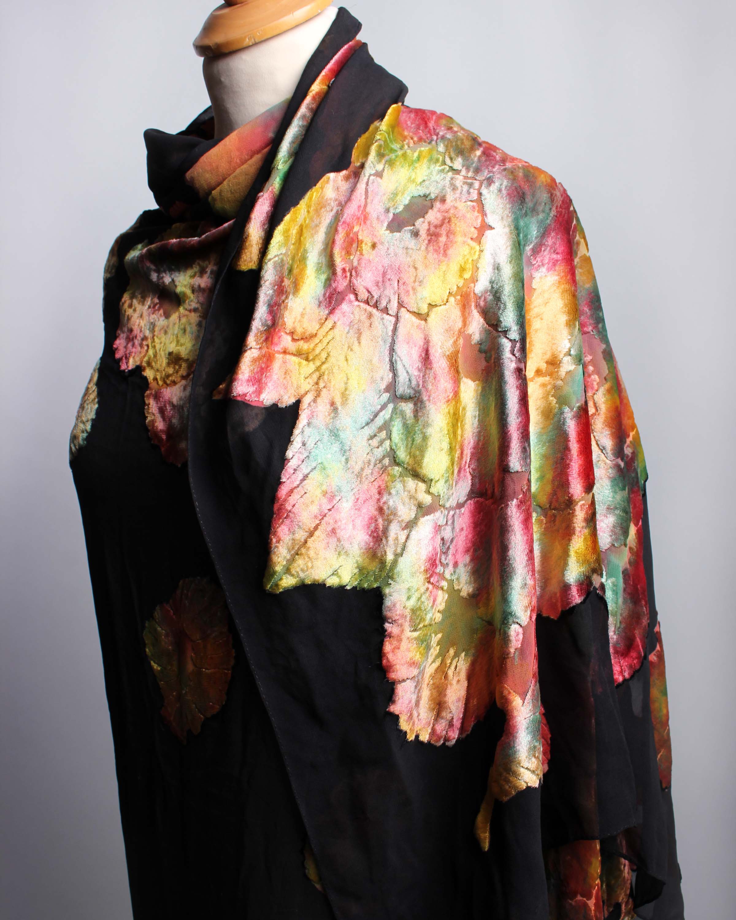 An early 20th Century black silk devoré shawl, decorated with stylised brightly coloured flowers. - Image 2 of 3