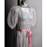 An early 20th Century full length voile dress embroidered with tiny pink flowers, scalloped neckline