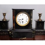 An Edwardian slate and marble mantle clock with matching candle garnitures.