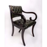 A mahogany arm chair with green leather button back upholstery and brass studding arms terminating