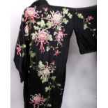 A 1920s black silk kimono embroidered with cream and pink flowers and a vibrant blue kimono of a