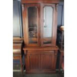 A William IV two part bookcase. Two glazed doors over single drawer and two cupboard doors raised on