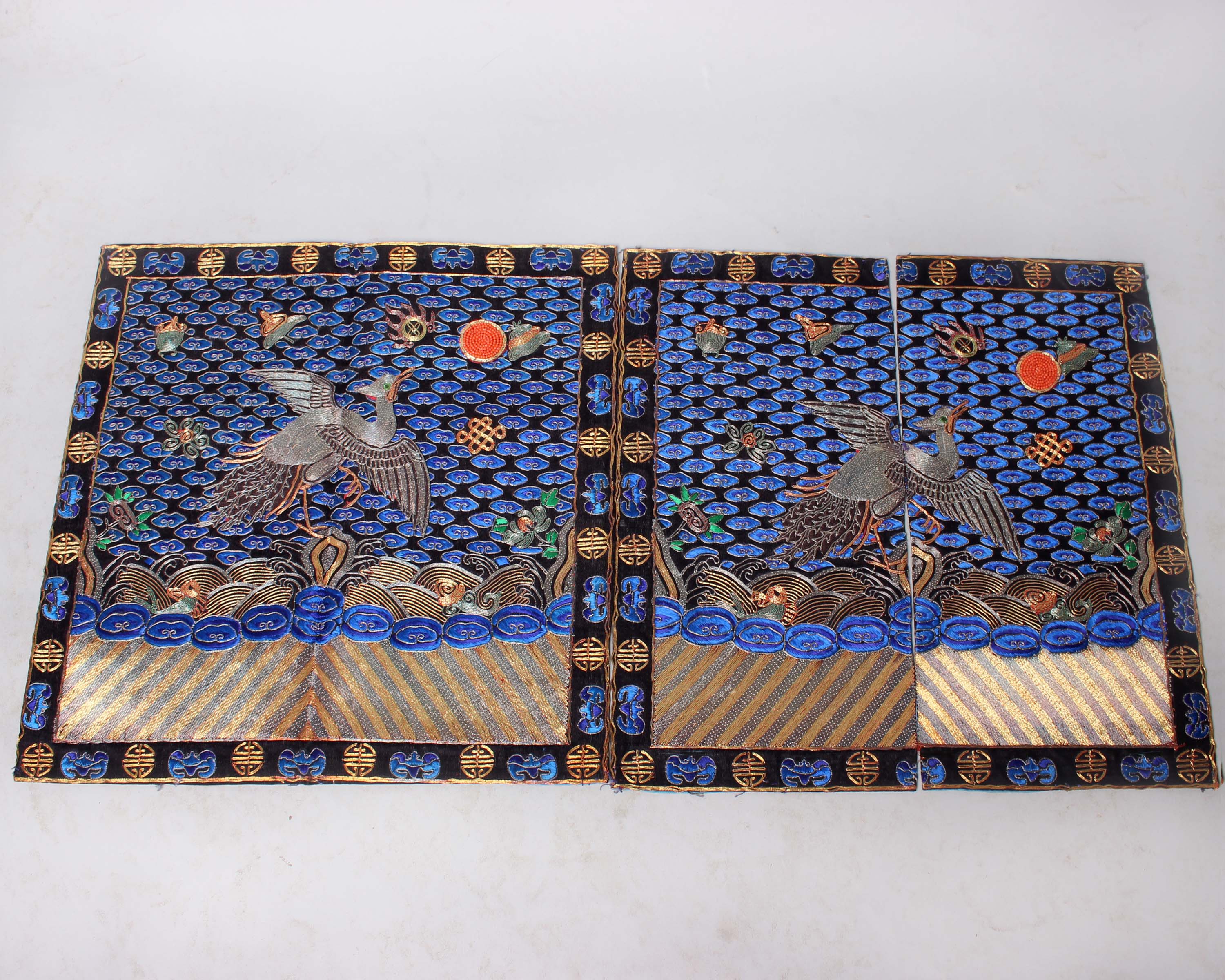 A pair of Qing dynasty Mandarin rank badges, showing the silver bird standing on a rock in the midst