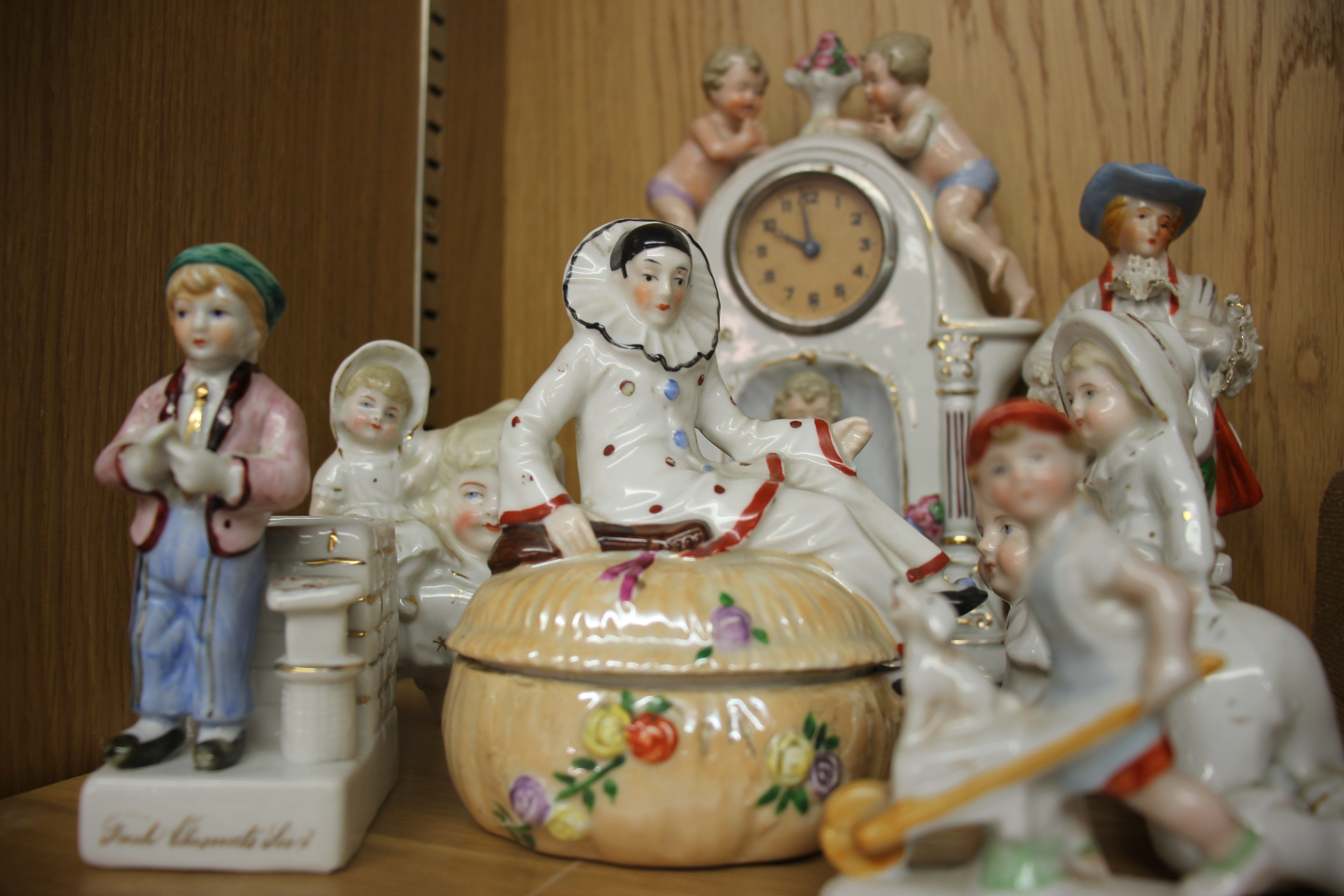 A Continental porcelain mantel timepiece; together with other Continental porcelain figurines.
