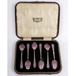 A boxed set of silver and enamel coffee spoons together with a boxed set of silver coffee spoons.