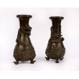 A pair of early 20th century Japanese bronze baluster shaped vases with applied cast dragon