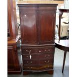 A reproduction mahogany finish cabinet on faux chest