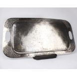 An Indian white metal tray with cast and planished decoration and pierced loop handles. 60cm x