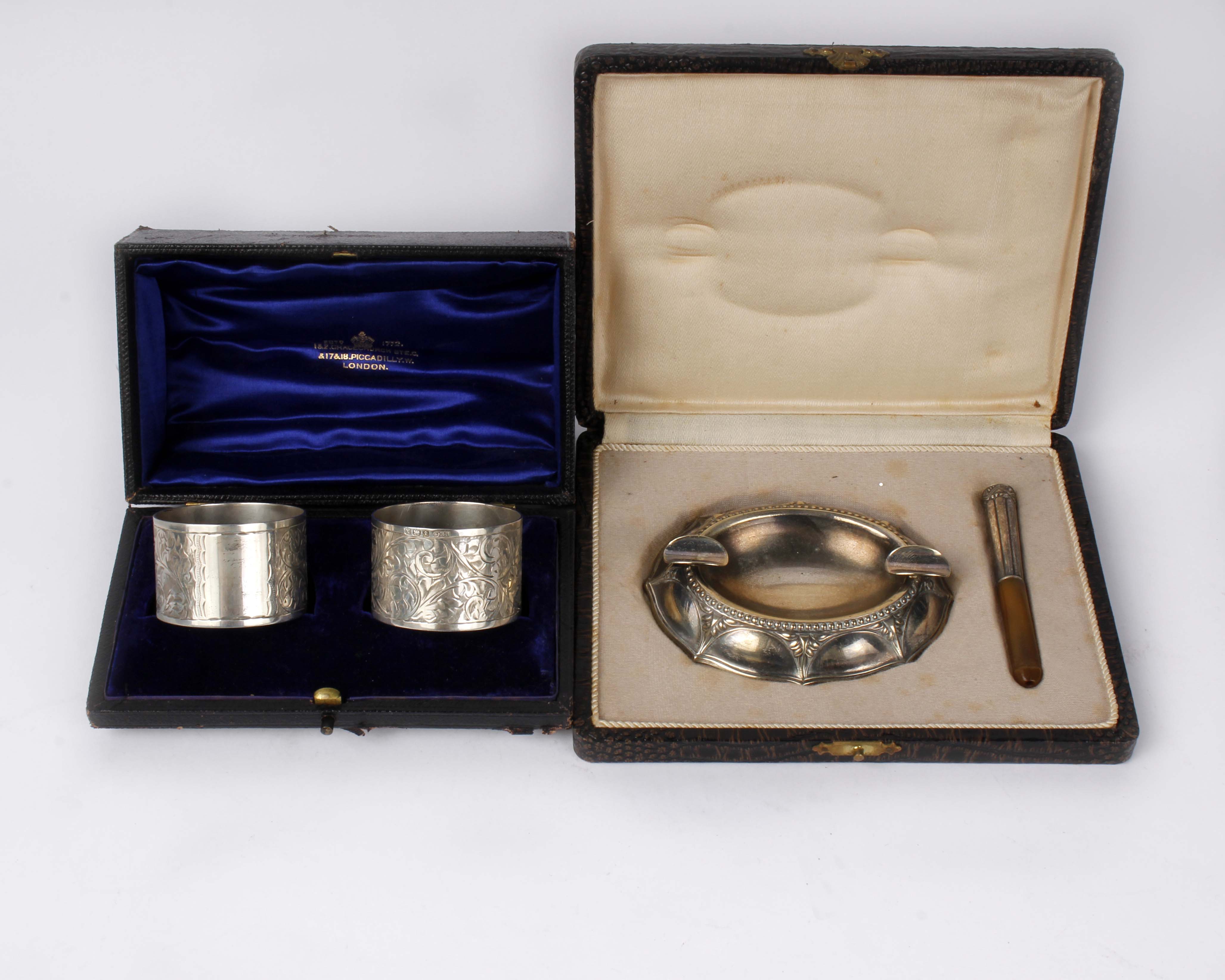 Two boxed white metal items, a pair of napkin rings and a boxed smoking set.