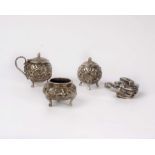 An Indian white metal condiment set with cast decoration together with a Chinese white metal model