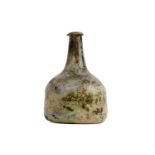 An early 18th Century iridescent green blown glass onion/mallet shaped wine bottle. 19cm(h).