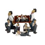 A collection of Laurel and Hardy ceramic figures, with wooden book support.