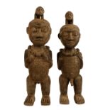 A large pair of carved figures in hardwood, one male and one female fertility figures. Early to