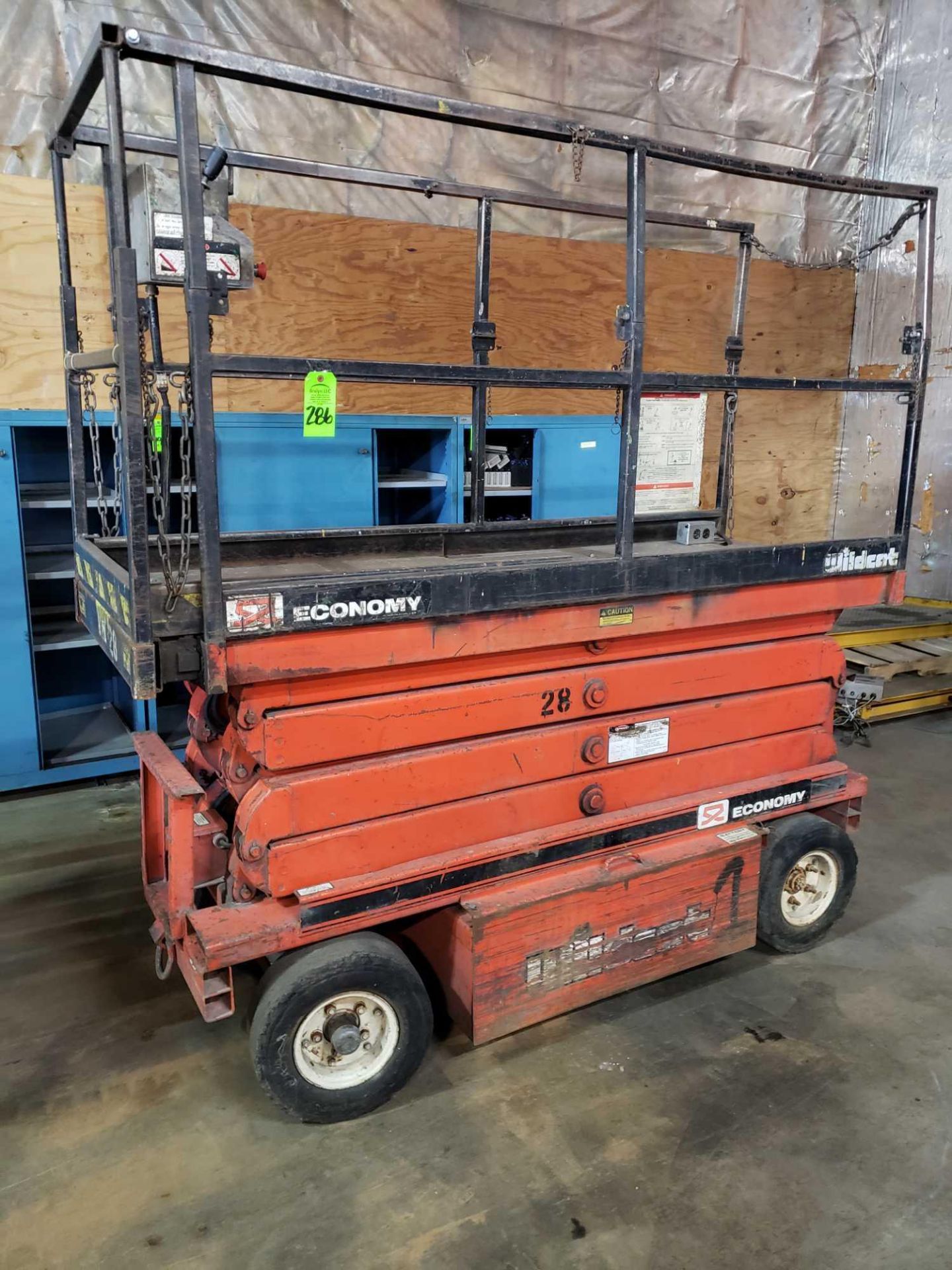 Economy Wildcat scissor lift. Estimated 30-32' lift height. No batteries included.