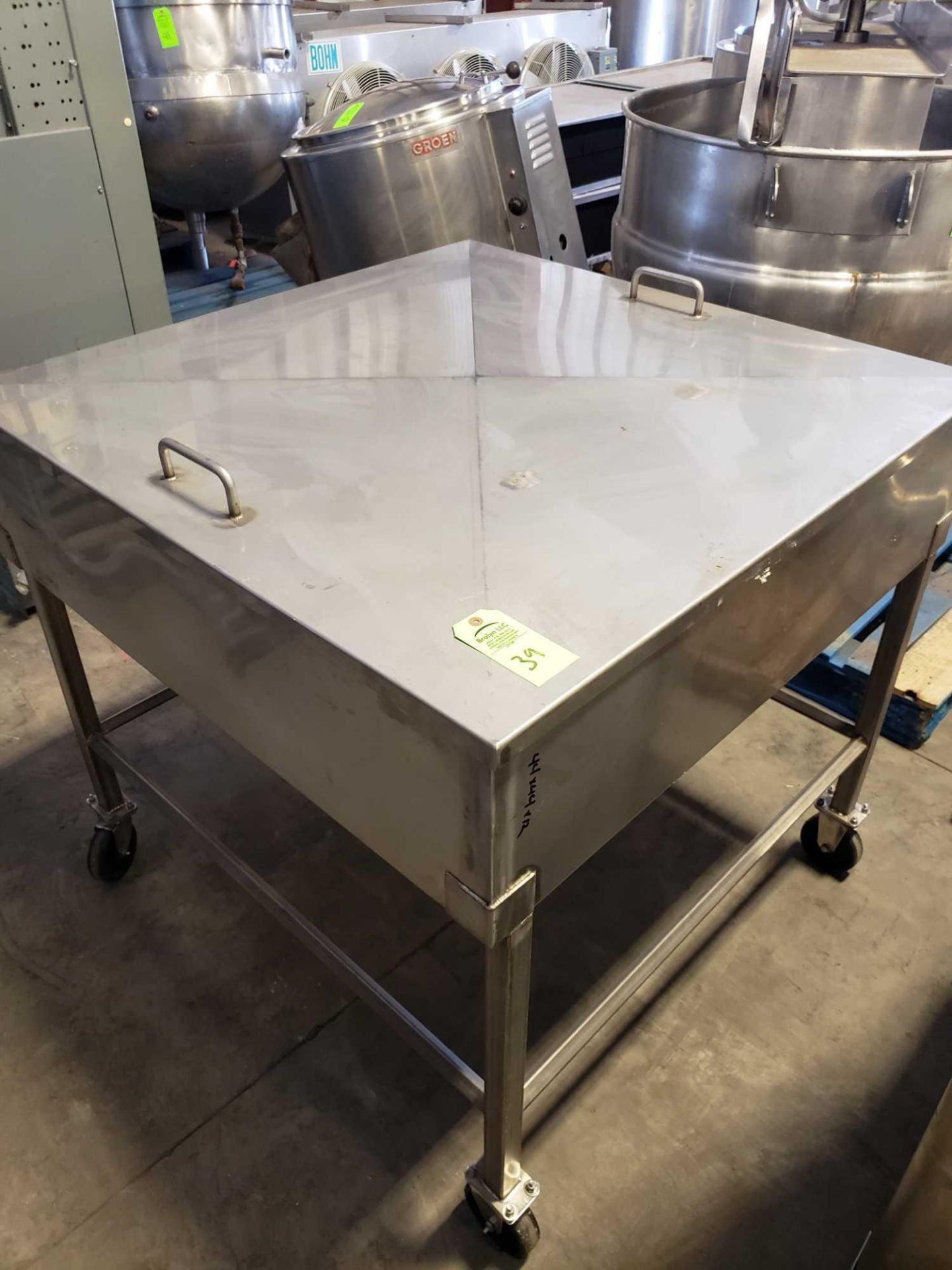 Stainless steel hopper, approx 44" wide x 44" long x 12" deep on casters with center feed drain