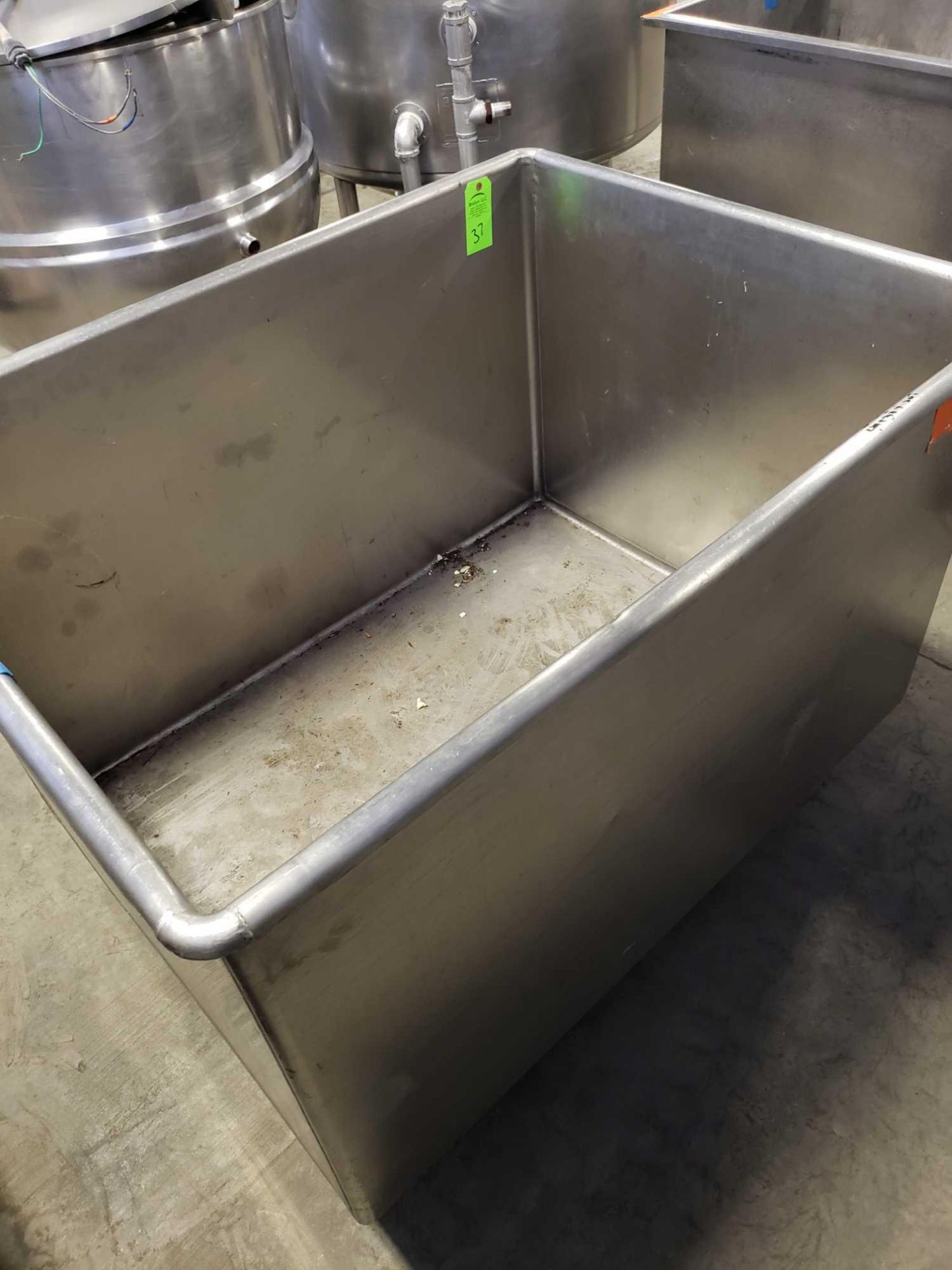 Stainless steel tank on casters with drain. Approx 49" wide by 38" deep by 30" tall.