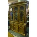 A Large French Style Oak Display Cabinet, With three glazed doors enclosing glass shelves, above