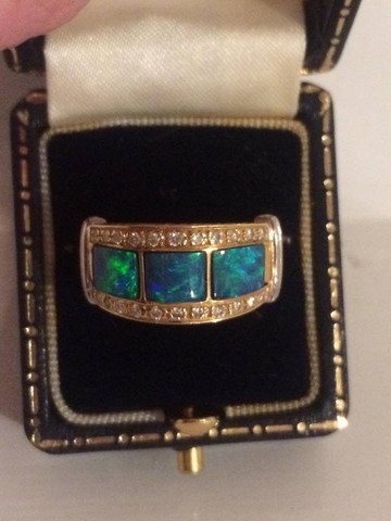 An Unmarked Gold Ladies Dress Ring, Set with three green centre stones possibly opals, surrounded by