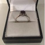 A Ladies Silver Dress Ring, Set with a single ruby coloured stone, ring size N1/2