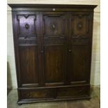 A Jacobean Style Oak Wardrobe, circa early 20th century, With a moulded cornice above three doors,