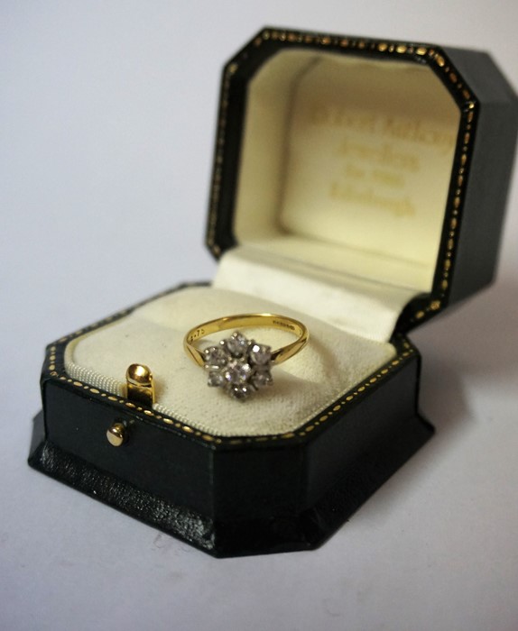 An 18ct Gold and Diamond Flowerhead Cluster Ring, with a central diamond stone measuring