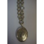 A Silver Locket, Hallmarks for Birmingham, 4cm diameter, on a white metal link chain, probably