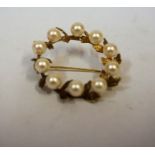 A 9ct Gold and Pearl Brooch, In the form of a wreath, set with ten pearls, indistinctly stamped to