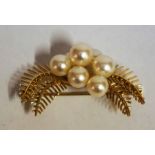 A 14ct Gold and Pearl Brooch, Set with seven cultured pearls on a gold leaf decorated mount, stamped