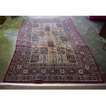 A Persian Style Machine Made Rug, Decorated with geometric and floral motifs on a red ground,