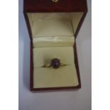 A 14ct Gold Star Sapphire Ring, The cabochon cut purple coloured star sapphire measuring