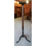 A Tall Mahogany Torchere, circa early 20th century, raised on a reeded column and tripod supports,