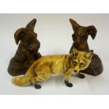 A German Porcelain Figure of a Fox, signed to underside, 23cm long, also with a pair of carved