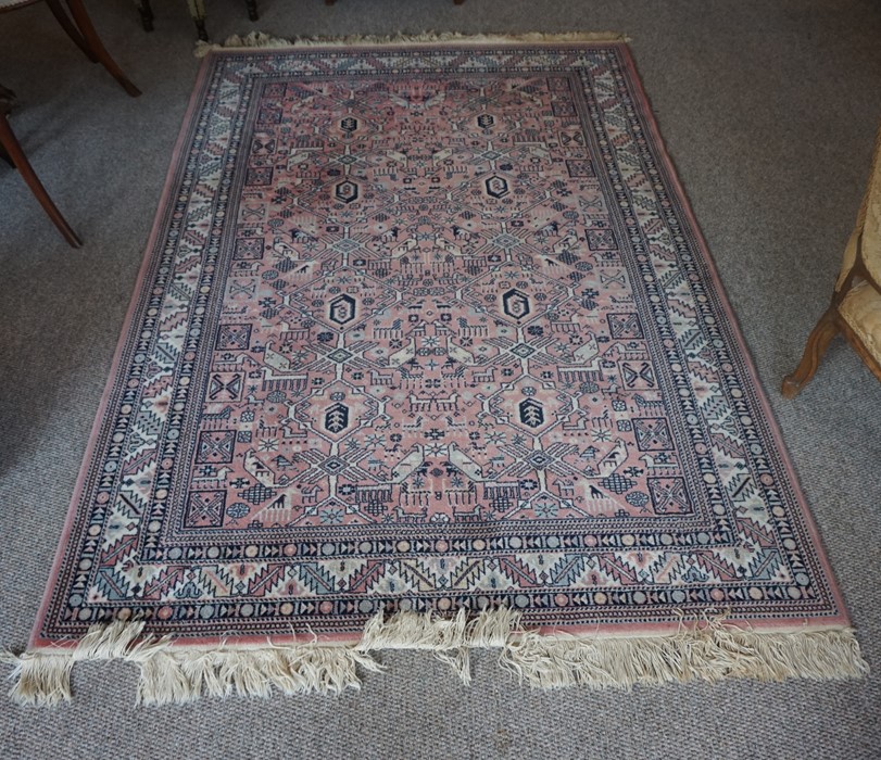 A Nerahbad Machine Made Rug, Decorated with Geometric motifs on a pink ground, 215cm x 141cm