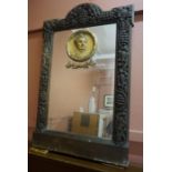 A Carved Wall Mirror, Decorated with a gesso portrait plaque to the mirror, mounted in a heavy oak