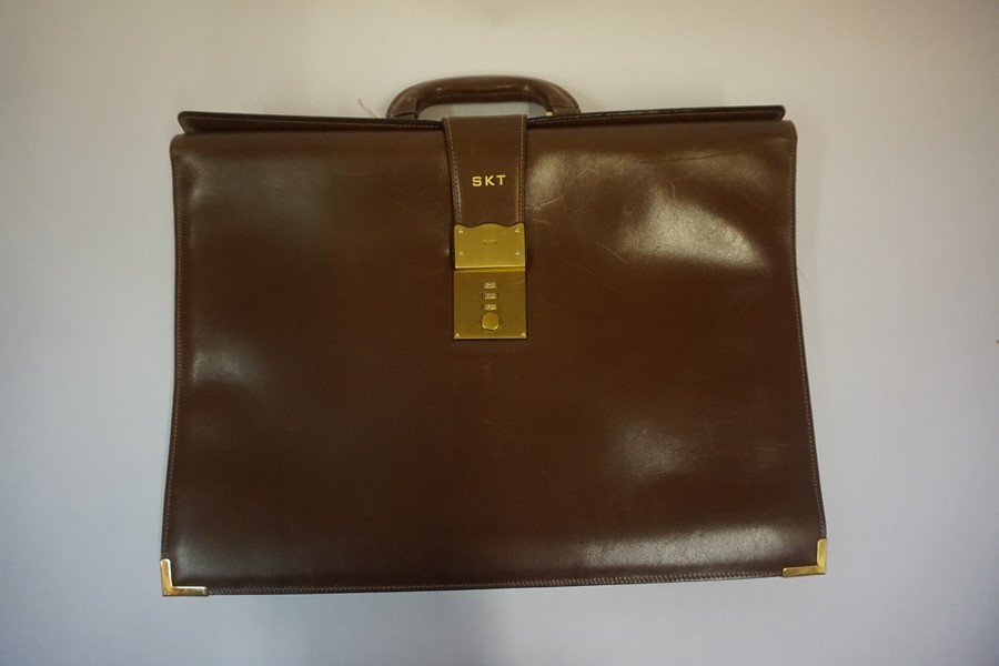 A Brown Leather Unisex Carry Bag named Gucci, with a combination lock. (Locked) 39cm high