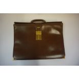 A Brown Leather Unisex Carry Bag named Gucci, with a combination lock. (Locked) 39cm high