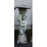 A Stone Garden Plant Stand, Modelled as a Putti style child, holding aloft a torchere, 86cm high