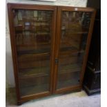 An Oak Bookcase, circa early 20th century, Having two glazed doors, enclosing a shelved interior,