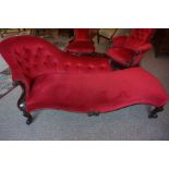 A Victorian Mahogany Chaise Longue, Upholstered in later red button back velour, Raised on scroll