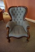 A Victorian Style Buttonback Armchair, Having a serpentine shaped seat, raised on scroll feet, 103cm