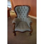 A Victorian Style Buttonback Armchair, Having a serpentine shaped seat, raised on scroll feet, 103cm