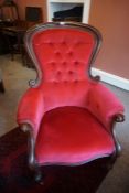 A Victorian Mahogany Gents Armchair, Upholstered in later red button back velour, raised on scroll