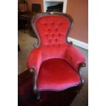 A Victorian Mahogany Gents Armchair, Upholstered in later red button back velour, raised on scroll