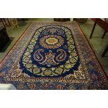 A Large Persian Carpet, Decorated with floral medallions and motifs on a blue ground, 375cm x 256cm