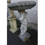 A Stone Garden Bird Bath, Modelled as a Putti style child holding aloft a torchere, 84cm high