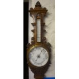 An Edwardian Carved Oak Wheel Barometer, Having a thermometer gauge above enamel dial, 88cm high