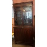 A Regency Mahogany Bookcase, circa early 19th century, Having two glazed astragal doors enclosing